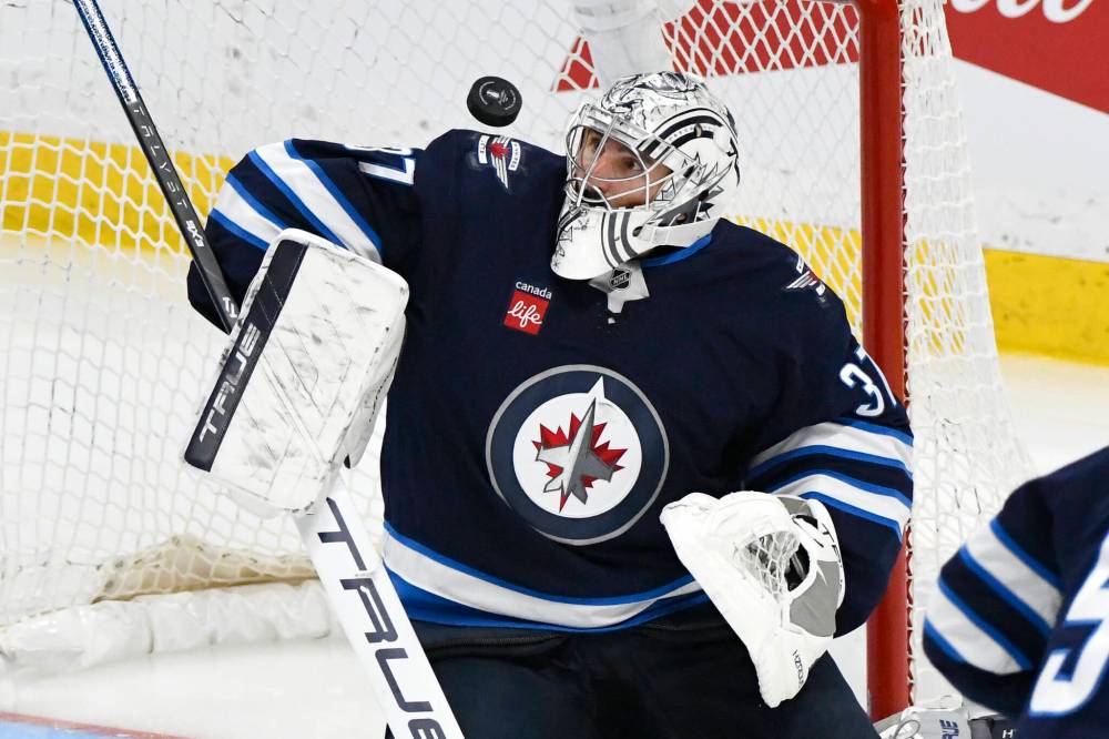 Winnipeg Jets goaltender Connor Hellebuyck (37) makes a save on a St. Louis Blues shot on April 21. (Fred Greenslade / The Canadian Press files)