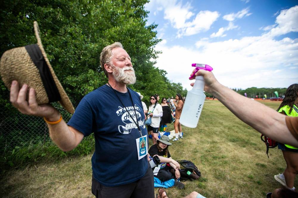 MIKAELA MACKENZIE / FREE PRESS
Longtime folk fest attendee Greg Docker enjoys a spritz of water at the site last week.
