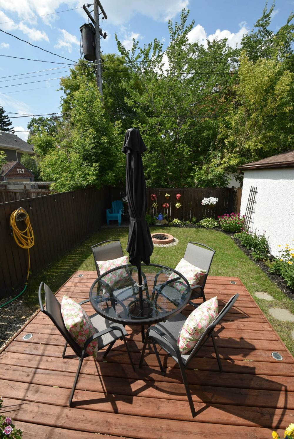 The private, fenced backyard has a deck, firepit and room to garden.