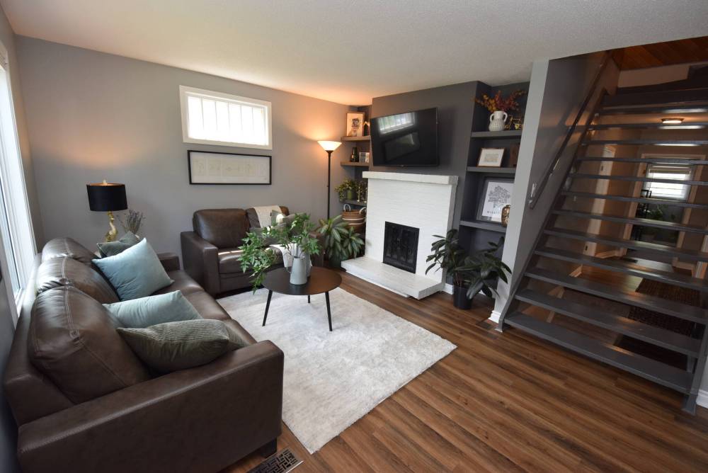 An open-riser staircase off the cosy living room with built-in shelving provides access to the home’s primary bedroom.
