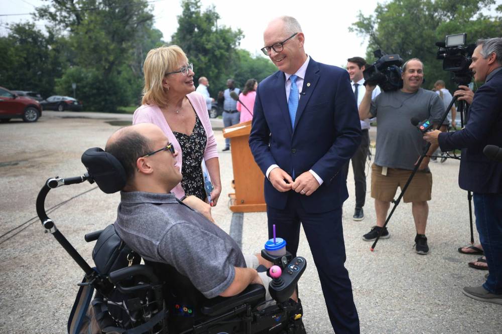 RUTH BONNEVILLE / FREE PRESS
Mayor Scott Gillingham talks with Bryce Nelson (wheelchair) and his mom, Margy Nelson, Special Projects Director, CoHabit, after the news conference at 825 Tache on developers selected to build affordable housing on city-owned properties.