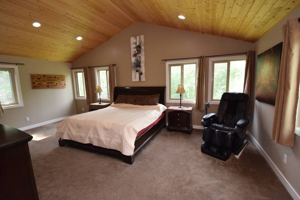 The loft-style primary bedroom has treetop views, a vaulted ceiling and an abundance of natural light.