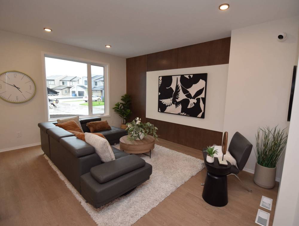 The generous great room is grounded by a warm cappuccino-stained woodgrain feature wall.