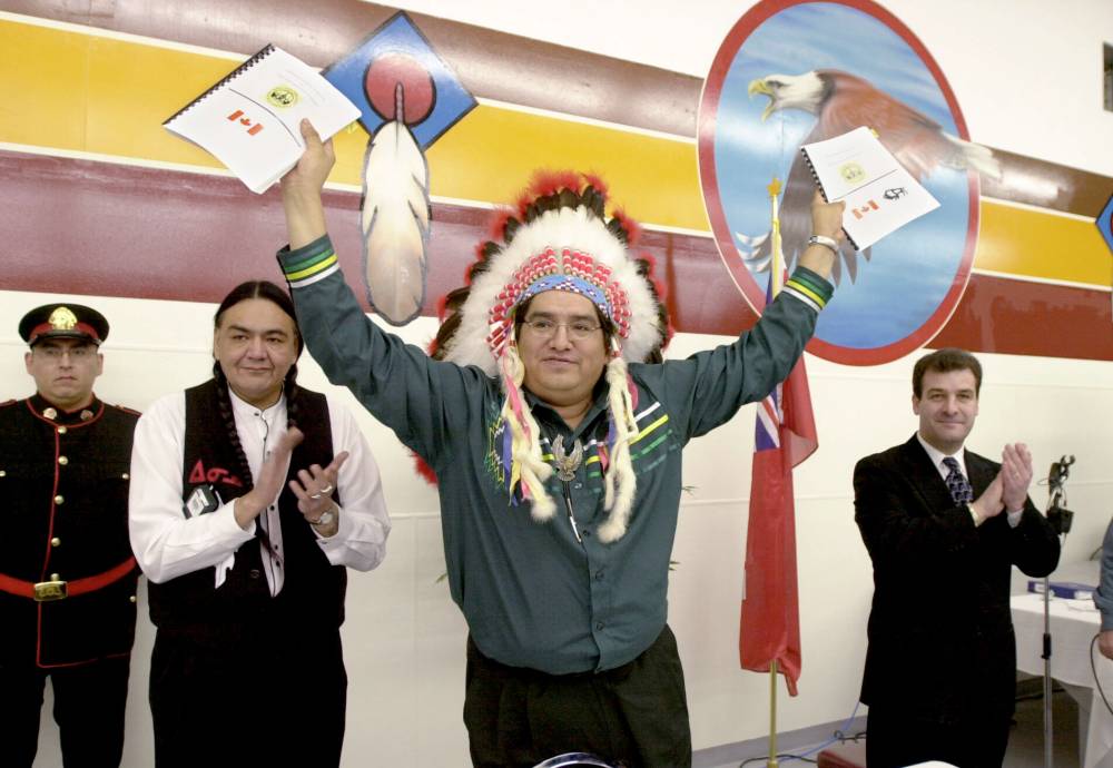 Fred Greenslade photo
In this 2001 photo, Chief Ken Whitecloud (centre) of Sioux Valley Dakota Nation holds up copies of the agreement in principle for self-government as Manitoba minister of Indian affairs Eric Robinson (left) and his federal counterpart, Robert Nault, applaud. The agreement came into effect in early 2014.