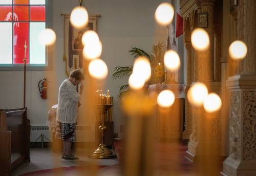 A woman pauses after lighting a candle before Sunday service at St. George’s Ukrainian Orthodox Church, in Dauphin, on June 18, 2023. (Darryl Dyck / The Canadian Press files)