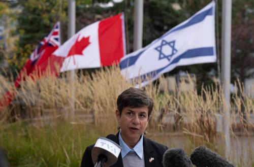 Adrian Wyld / The Canadian Press files
                                The flags of Ontario, Canada and Israel fly at half mast as Jewish Federation of Ottawa CEO Andrea Freedman reads a statement from the family of Adi Vital-Kaploun Oct. 11, 2023, in Ottawa.