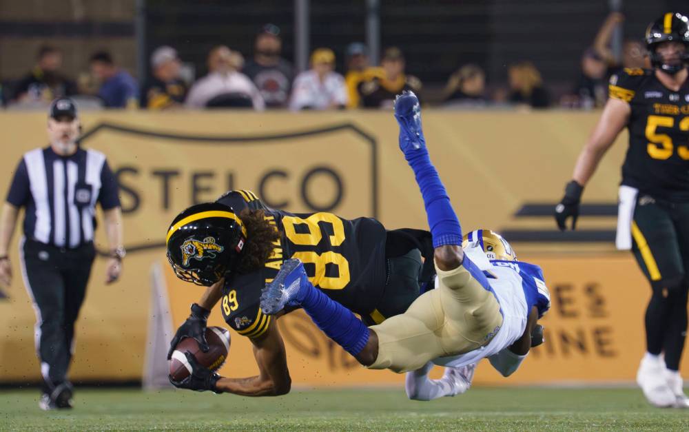 PETER POWER / THE CANADIAN PRESS
Hamilton Tiger-Cats wide receiver Kenny Lawler (89) makes a catch while defended by Winnipeg Blue Bombers defensive back Demerio Houston (9) during first half CFL football game action in Hamilton, Ont. on Friday, September 12, 2025.