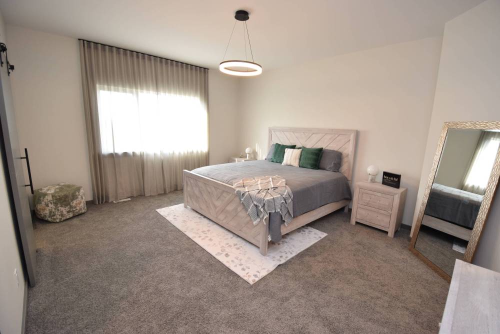Soft, earthy tones give the spacious primary bedroom a relaxing air.