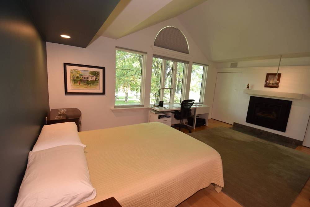 The primary bedroom boasts a vaulted ceiling, gas fireplace and a lovely view.