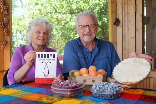 Brook Jones / Free Press
                                Jan Schmidt, 70, (left) holds a book about Jackson Nahayo, who started the Ubuntu Clinic, while her husband, John David Pankratz, 71, displays a pie he baked.