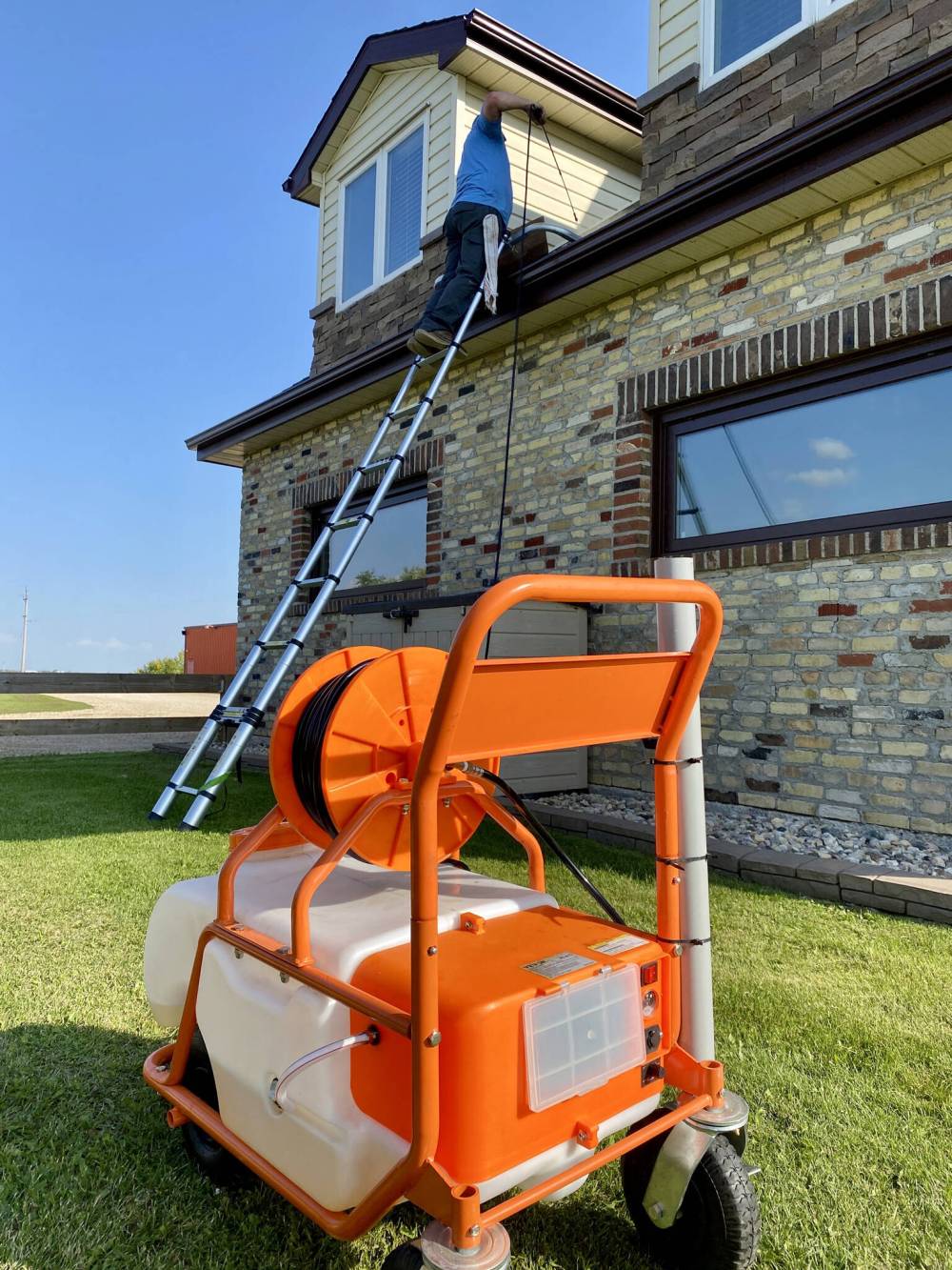 Marc LaBossiere / Free Press
The portable battery-operated sprayer remains on the ground, while the hose and spray-wand are used on the roof.