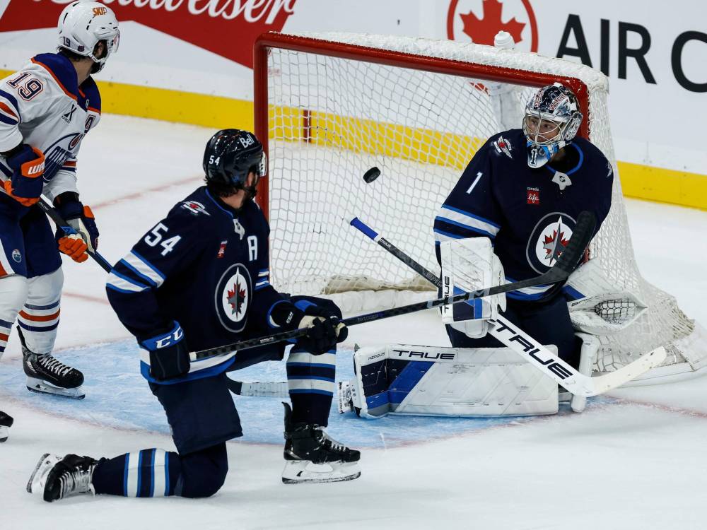 JOHN WOODS / FREE PRESS FILES
Winnipeg Jets’ Dylan Samberg (54) and Edmonton Oilers’ Adam Henrique (19) look on as a shot gets past goaltender Eric Comrie (1) during the Sept. 23 preseason game. Coach Scott Arniel called Samberg’s injury a “freak accident.”