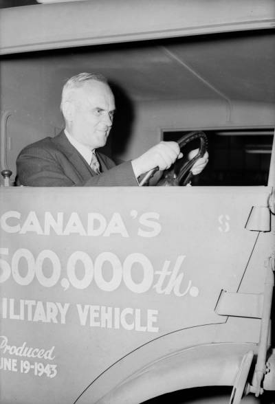 National Film Board of Canada / Library and Archives Canada
                                C.D. Howe gets the feel of things by taking hold of a steering wheel during ceremonies on June 19, 1943, that marked the delivery of the half-millionth unit of motorized equipment produced in Canada during the Second World War.