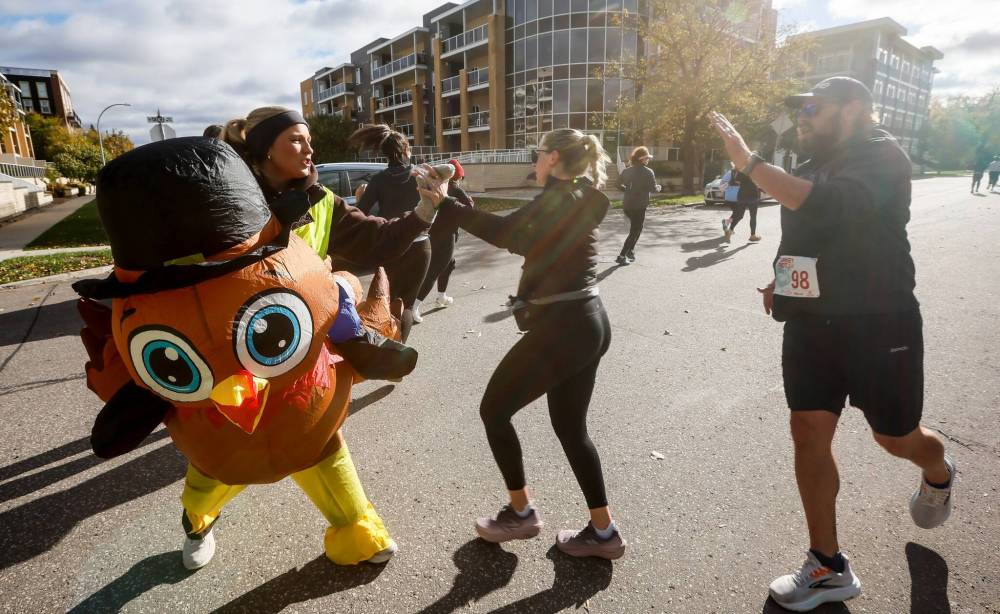 JOHN WOODS / FREE PRESS
Volunteer Dana greets Turkey Trot runners.