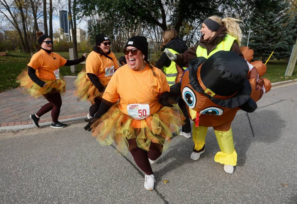 JOHN WOODS / FREE PRESS
From left, runners Kayla, Kayla and Vickey high-five volunteers Lauren, Emily, and Dana.