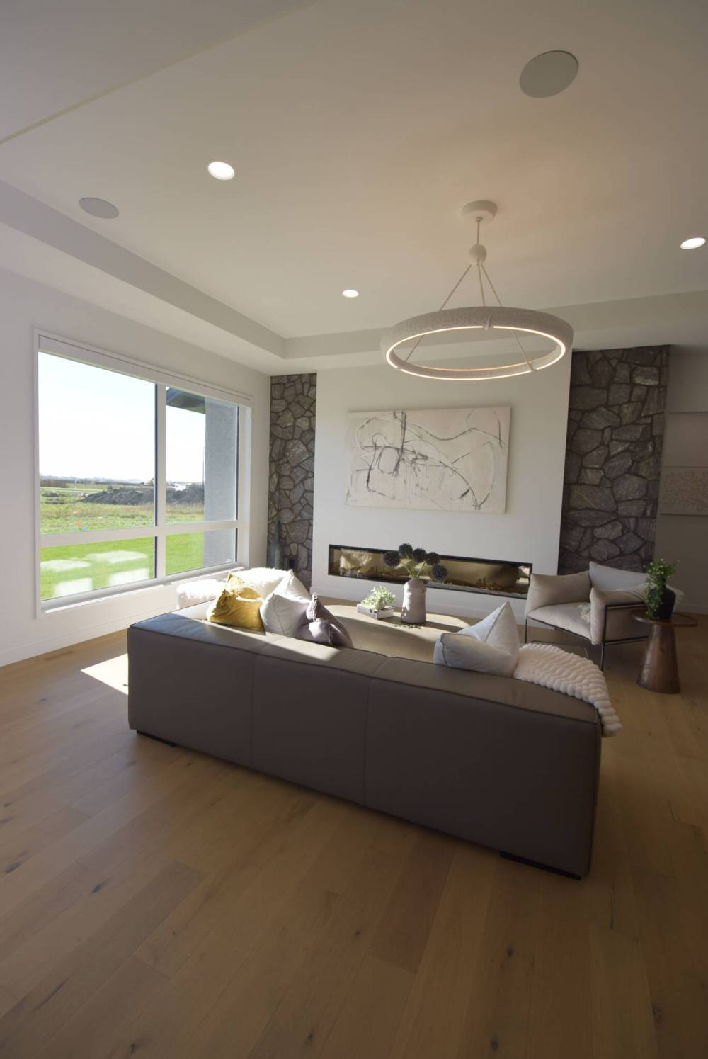 PHOTos by Todd Lewys / Free Press
A 100-inch linear electric fireplace set in a white drywall feature wall with stone trim on either side is the centrepiece of the alluring room.
Todd Lewys / Free Press
A nine-foot island with matte-black porcelain countertop, waterfall sides and warm woodgrain-style cabinetry serves as the anchor point of the elegantly understated kitchen in Artista Homes’ spacious bungalow in Forest Grove Estates.