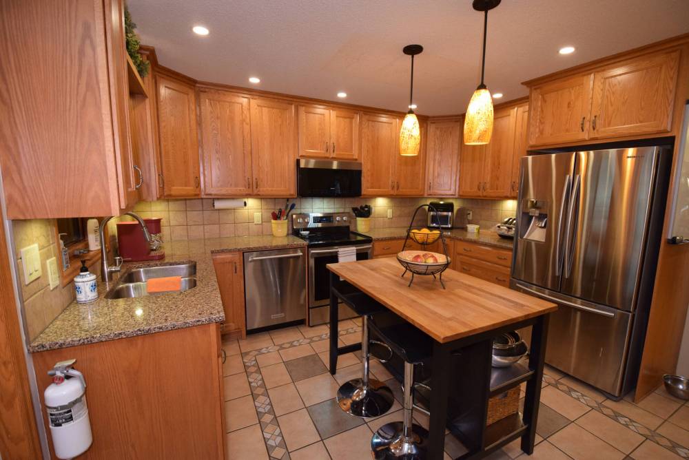 TODD LEWYS / FREE PRESS
The upgraded kitchen offers a tile floor, island, tons of oak cabinets, tile backsplash, granite countertops and stainless-steel appliances.