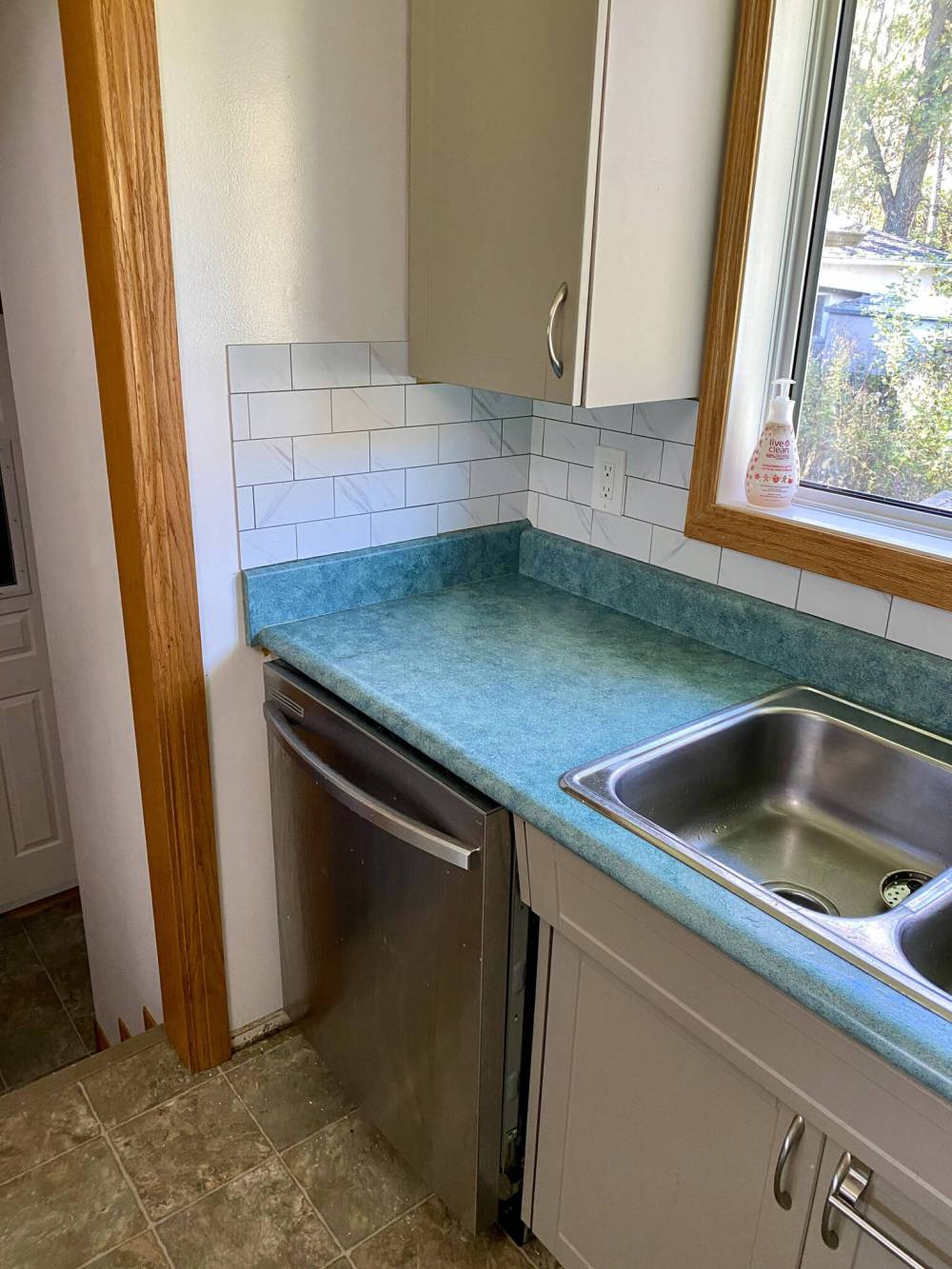 Starting at one clean end, the peel-and-stick tile mosaic is built along the wall.