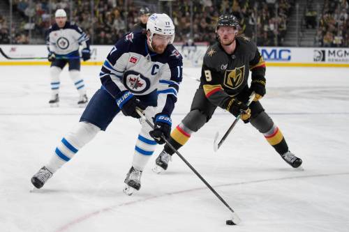 John Locher / The Associated Press files
                                Jets captain Adam Lowry (left) will see his first game action of the season, Tuesday, against the L.A. Kings.