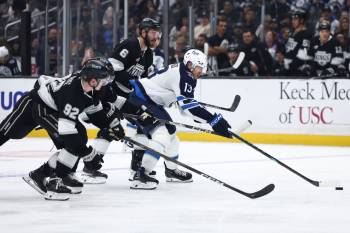 Winnipeg Jets centre Gabriel Vilardi (13) battles for the puck against Los Angeles Kings defenseman Brandt Clarke (92), left wing Jeff Malott, second from left, and defenseman Joel Edmundson (6) during the third period of an NHL hockey game, Tuesday, Nov. 4, 2025, in Los Angeles. (Jessie Alcheh / The Associated Press)