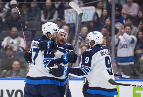 Winnipeg Jets’ Adam Lowry, front left to right, Nino Niederreiter and Alex Iafallo celebrate Niederreiter’s goal against the Vancouver Canucks during the first period of an NHL hockey game, in Vancouver, on Tuesday. (Darryl Dyck / The Canadian Press)