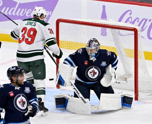 FRED GREENSLADE / THE CANADIAN PRESS
                                Winnipeg Jets&rsquo; goaltender Eric Comrie (1) makes a save on a Minnesota Wild shot as Ben Jones (39) looks for the rebound during the third period of Sunday&rsquo;s game.