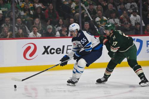 Winnipeg Jets center Mark Scheifele (55) takes control of the puck from Minnesota Wild left wing Marcus Foligno during the first period of an NHL hockey game, Thursday, Jan. 15, 2025, in St. Paul, Minn. (AP Photo/Craig Lassig)