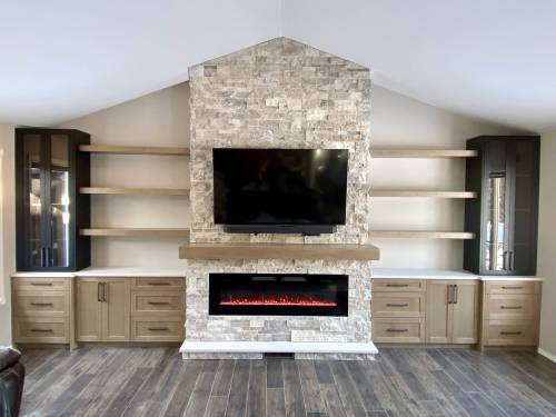 Photos by Marc LaBossiere / Free Press
                                The feature fireplace wall spans 19 feet, and showcases a stone-clad fireplace stack, hearth and mantle, with symmetrical cabinetry and floating shelves on either side.