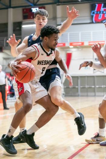 BROOK JONES/FREE PRESS
                                Wesmen guard Emmanuel Ugbah (No. 8) drives to the hoop while Thunderbirds forward Nikola Guzina (No. 6) defends during second quarter action Saturday.