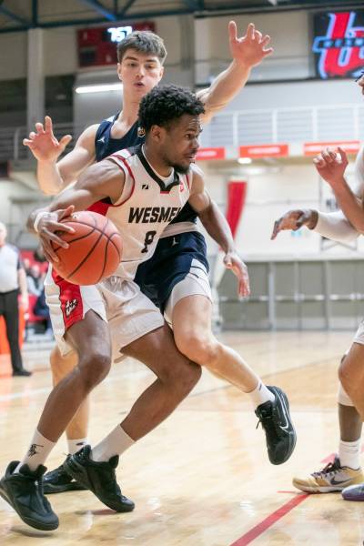 BROOK JONES/FREE PRESS
                                Wesmen guard Emmanuel Ugbah (No. 8) drives to the hoop while Thunderbirds forward Nikola Guzina (No. 6) defends during second quarter action Saturday.