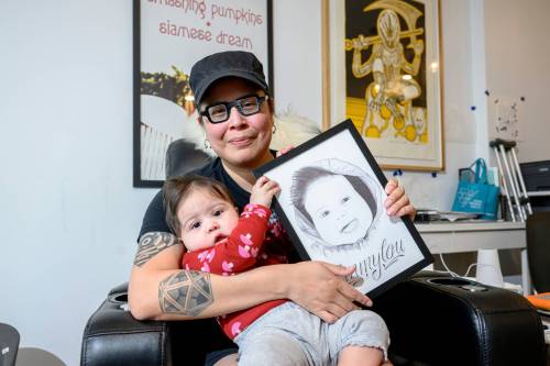 Mike Sudoma/Free Press
                                Winnipeg artist Dee Barsy and her daughter Emmylou hold a drawing of Emmylou done by Richard Daniels, with lettering by Bram Adey, a local tattoo artist.