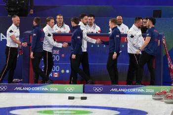 Canada&rsquo;s Brad Jacobs rink shakes hands with Britain&rsquo;s Bruce Mouat rink at the men&rsquo;s curling gold medal match between Britain and Canada, at the Winter Olympics in Italy. (AP Photo/Fatima Shbair)