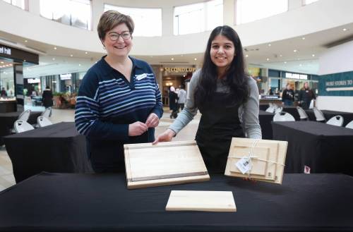 Ruth Bonneville / Free Press
                                Morden Collegiate Institute student Tasvee Jain shows off Luxe Prep cutting boards alongside JA Manitoba program manager Jeanette Bergmann at St. Vital Shopping Centre.