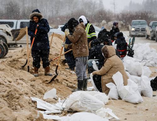 JOHN WOODS / THE CANADIAN PRESS FILES
                                People fill sandbags at Peguis First Nation. More than 500,000 sandbags and 11,000 super sandbags have been sent to the community to help.