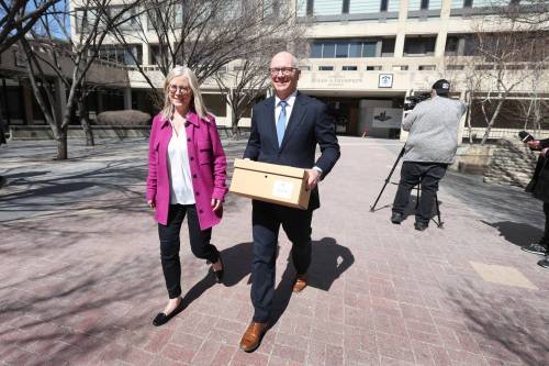 RUTH BONNEVILLE / FREE PRESS
                                Scott Gillingham, with his wife Marla, leaves City Hall on Friday with a box of documents after officially registering for the civic election in October.