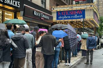 Fans line up in the rain outside the Ed Sullivan Theater in New York on Thursday, ahead of the final episode of &ldquo;The Late Show with Stephen Colbert.&rdquo; (Ted Shaffrey / The Associated Press files)
