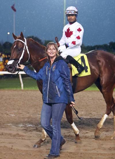 Jason Halstead / Assiniboia Photo
                                Groom Katie Morris leads Truly Unbelievable and jockey Kimal Santo into the winner&rsquo;s circle after their victory in the $25,000 Corporate Shuffle Stakes on Tuesday for trainer Robertino Diodoro.