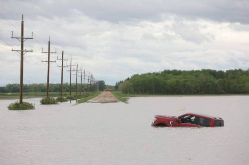 Tim Smith / The Brandon Sun Files
                                A pickup trucks sits partially submerged in floodwaters along Highway 83 south of Swan River last Wednesday after sustained rainfall earlier in the week caused widespread flooding.