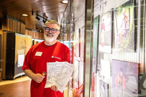 MIKAELA MACKENZIE / FREE PRESS
                                Volunteer JD Hawk with colouring pages made from his oil paintings at the Lower Fort Garry historic site on Wednesday.
