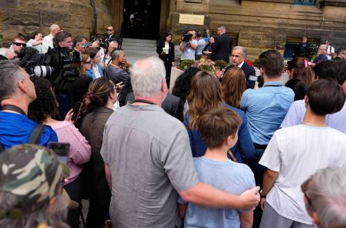 Justin Tang / THE CANADIAN PRESS
                                Visitors to downtown Ottawa and Parliament Hill listen as Prime Minister Mark Carney takes questions from journalists outside the Office of the Prime Minister on Tuesday.