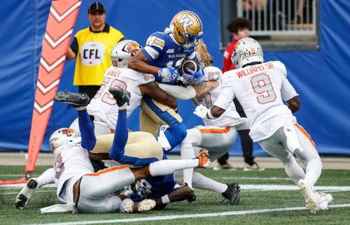 JOHN WOODS / THE CANADIAN PRESS
                                Winnipeg Blue Bombers&rsquo; Tim White (12) attempts to make it to the end zone against the B.C. Lions during the first half Thursday at Princess Auto Stadium.