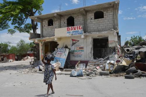 Odelyn Joseph / The Associated Press
                                A woman leaves her home to escape clashes between armed gangs in the Cite Soleil neighbourhood of Port-au-Prince, Haiti in May.