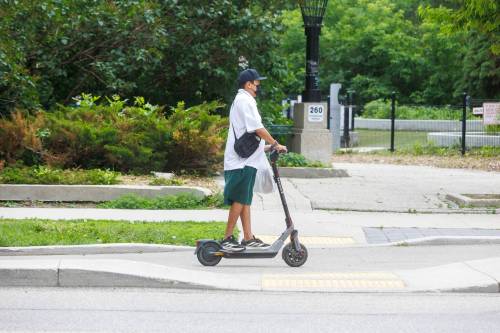MIKE DEAL / FREE PRESS
                                An E-scooter rider makes their way along Assiniboine Avenue.