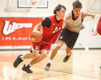 DAVE LARKINS / WESMEN ATHLETICS
                                Winnipeg Wesmen guard Kato Jaro (left) drives the ball against University of South Dakota defenders last week in pre-season action.