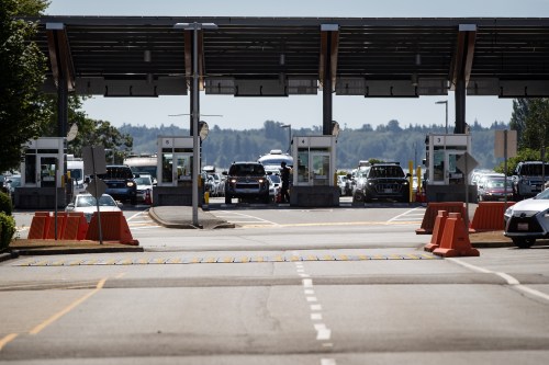 A Canada Border Services Agency officer is silhouetted as motorists wait to enter Canada at the Douglas-Peace Arch border crossing, in Surrey, B.C., on Monday, August 9, 2021. THE CANADIAN PRESS/Darryl Dyck
