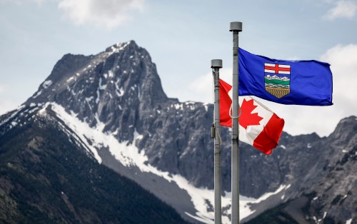 A Canadian flag, left, and an Alberta flag flap in the breeze with Wedge Mountain in the background at the site of the G7 Leaders meeting in Kananaskis, Alta., on Monday, June 2, 2025. THE CANADIAN PRESS/Jeff McIntosh