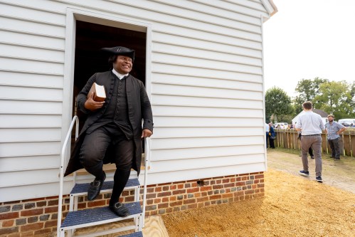 Joe Feaster, a part-time historical interpreter who portrays pastor Gowan Pamphlet, steps out of the reconstructed African Baptist Meeting House, now known as First Baptist Church of Williamsburg, during a rededication ceremony in Williamsburg, Va., Friday, Oct. 9, 2026. (AP Photo/Mike Kropf)