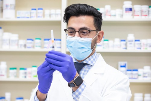 Pharmacist Mina Iskander prepares to administer a flu shot, at a pharmacy in Toronto on Thursday, November 18, 2021.THE CANADIAN PRESS/Chris Young